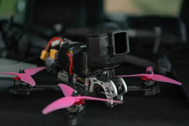 Drone FPV com câmera de ação e hélices rosas