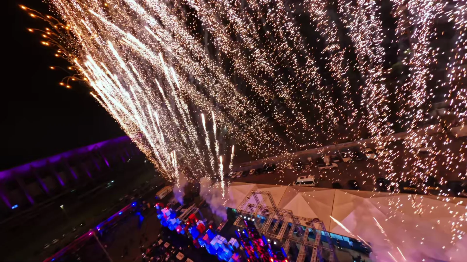Voo sobre um palco com fogos de artifício e público